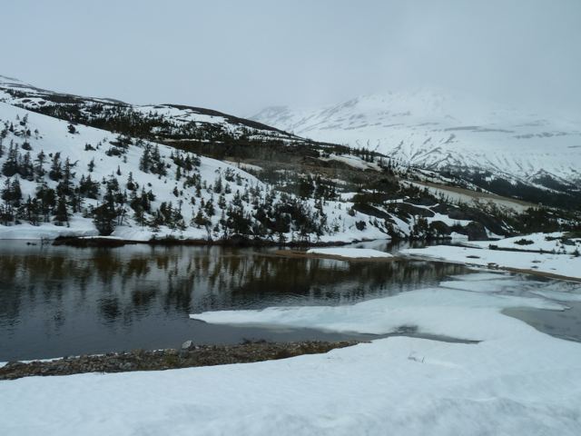 Snow beside a mountain lake