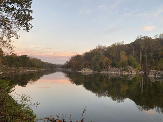 Still river at sunset reflecting autumn trees
