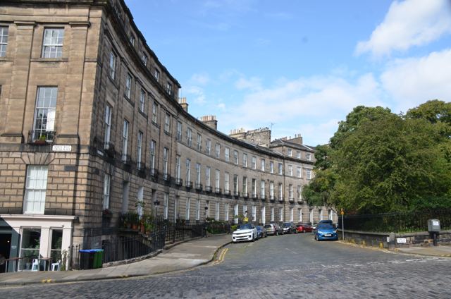 A curved terrace of stone townhouses