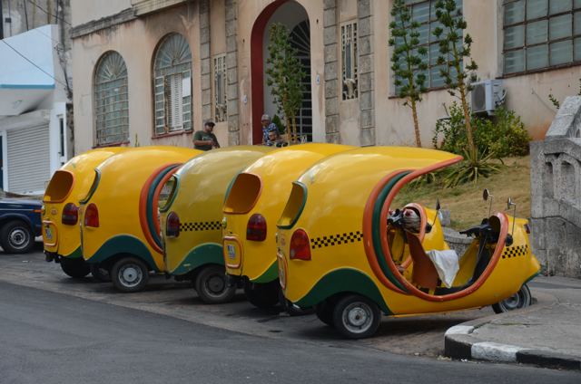 Yellow coco taxis parked at the kerb