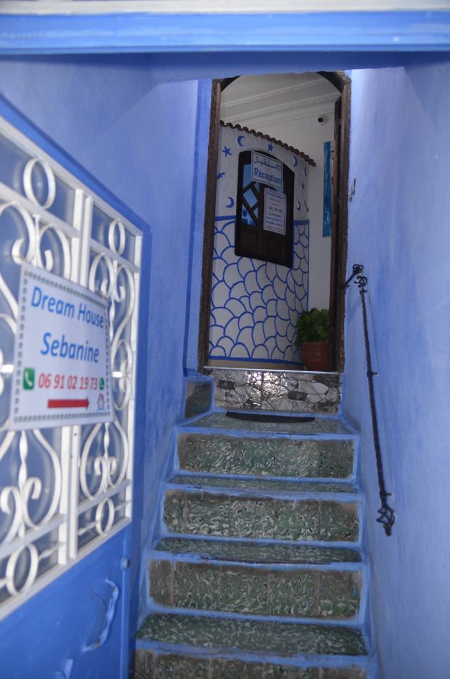 Blue stairway behind a white metalwork gate