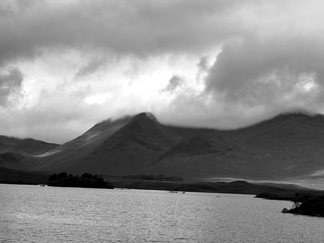 Dark mountains above a loch under heavy cloud