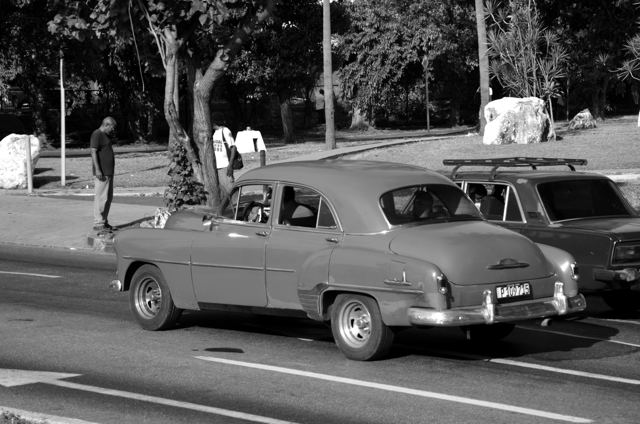 A teal vintage car on the road