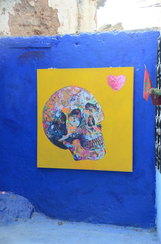 A painted skull artwork on a blue wall