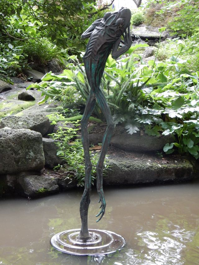 A bronze sculpture rising from a pond