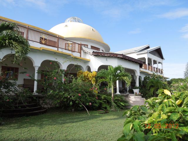 A white-domed house among gardens and palms