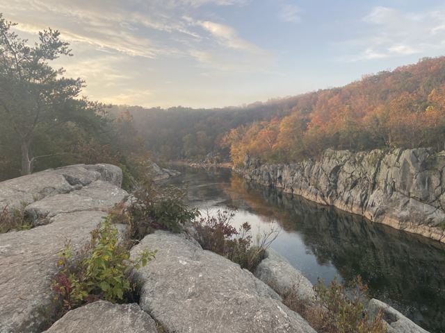 Rock outcrop above a river gorge with autumn-coloured cliffs beyond