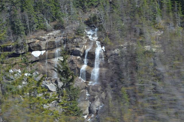 A waterfall running down a forested cliff