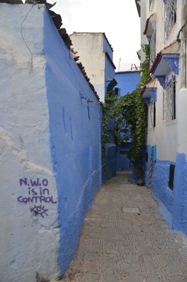 A narrow alley between blue-painted walls