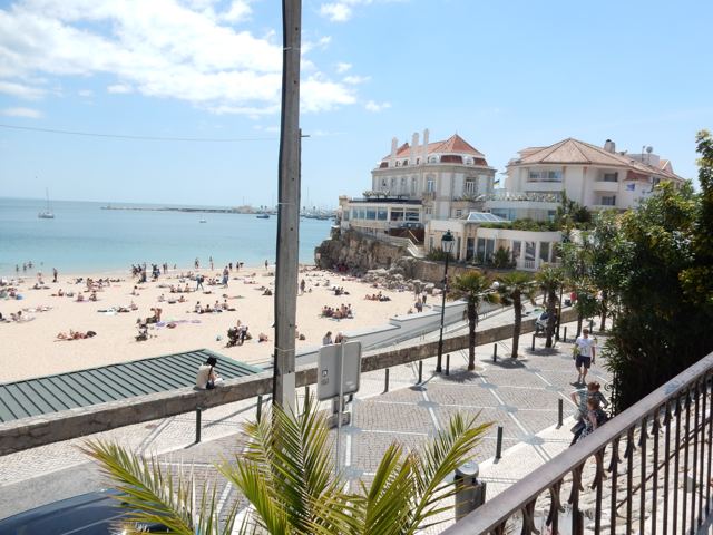 A beach and seafront buildings on a sunny coast