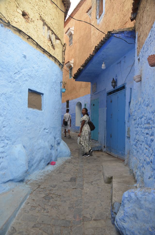 A blue alley sloping down between houses
