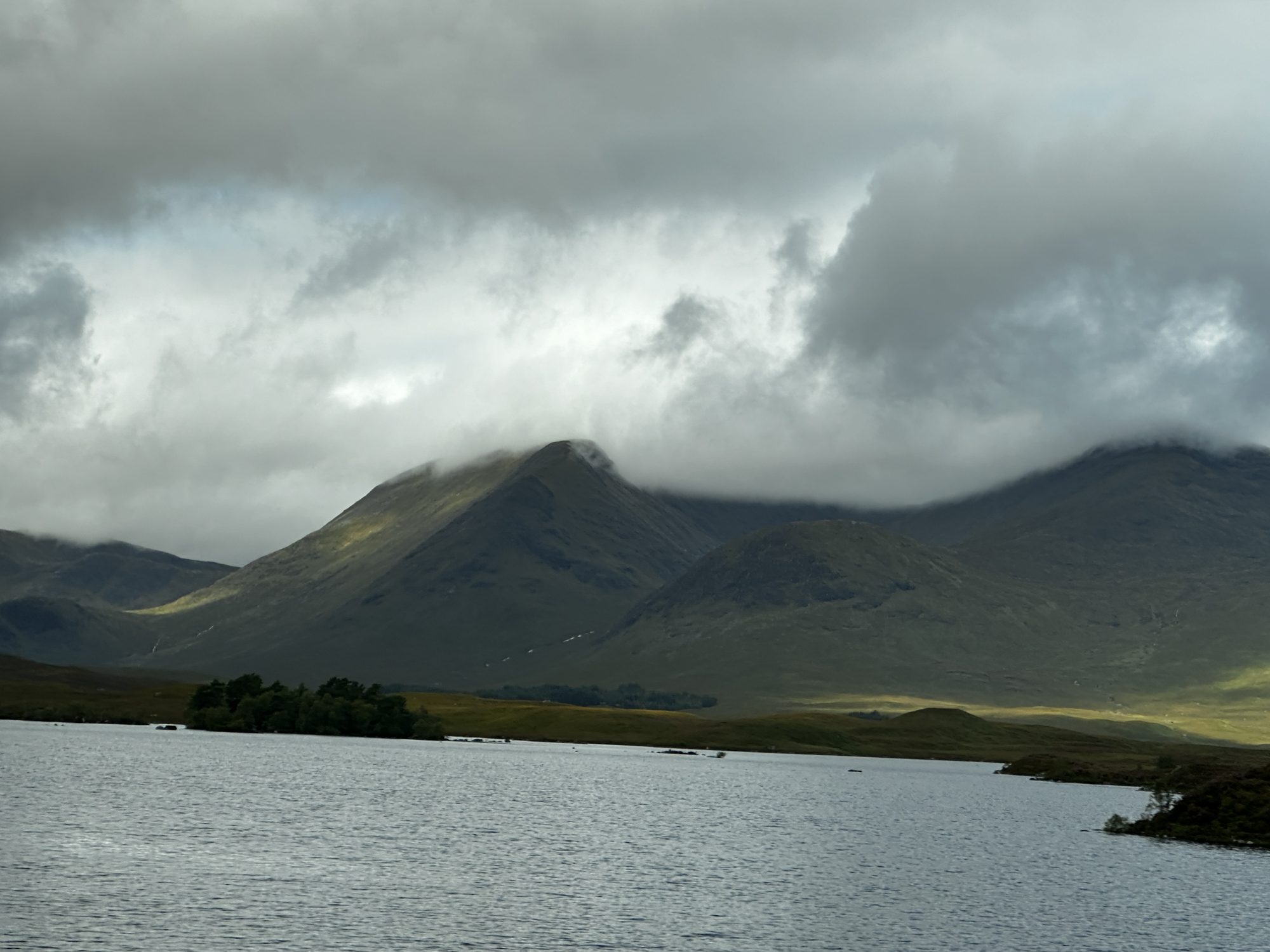 Dark mountains above a loch under heavy cloud