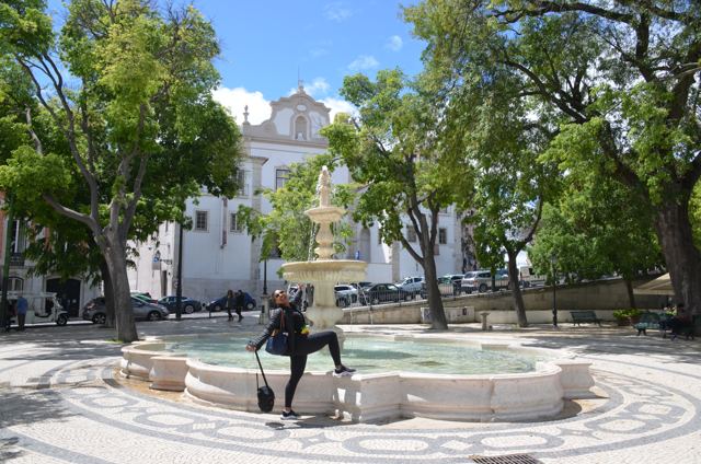 A fountain and trees in a tiled square