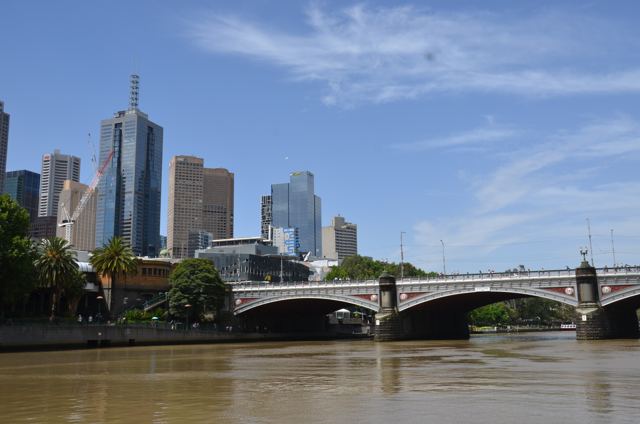 A city skyline beside a river bridge