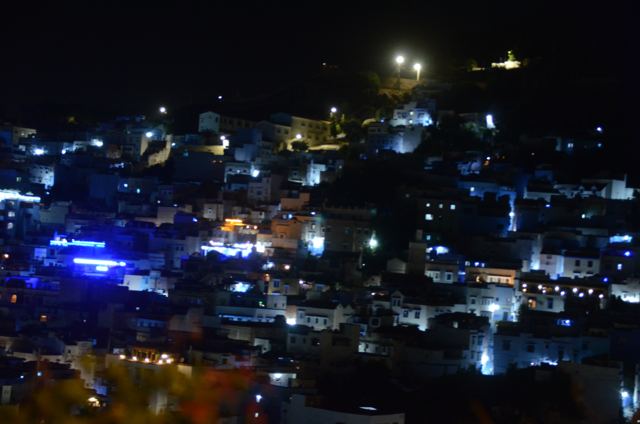 The hillside town lit up at night