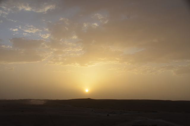 The sun sinking through desert haze