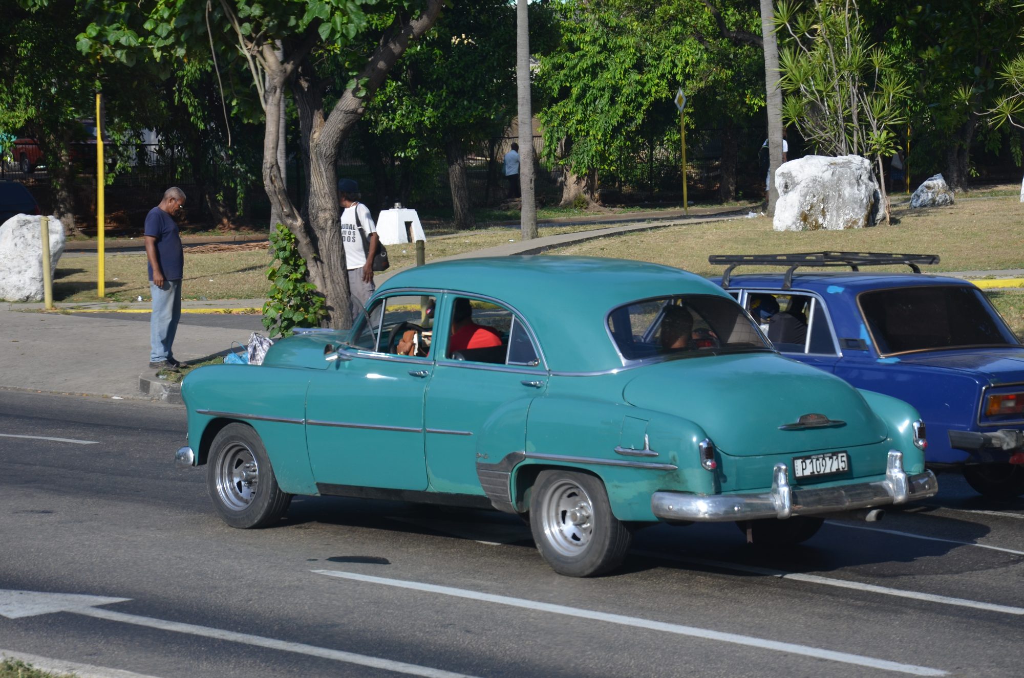 A teal vintage car on the road