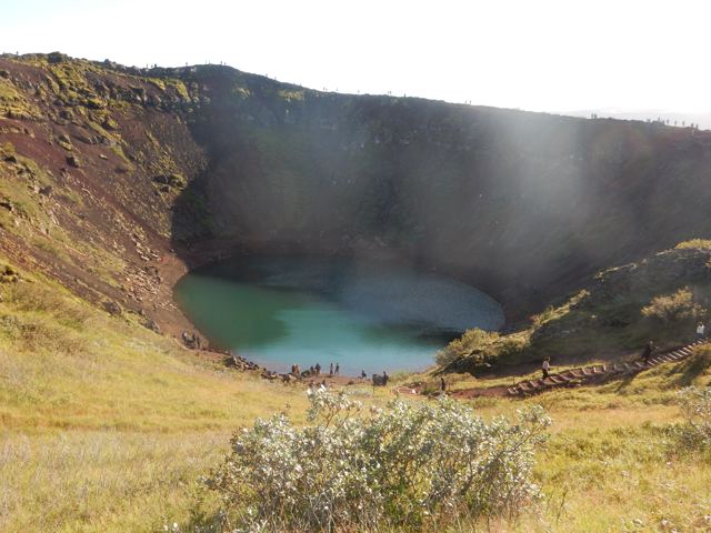 A turquoise crater lake in red volcanic rock