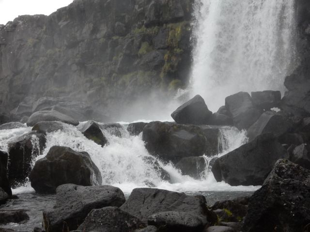 Water pouring over black rocks
